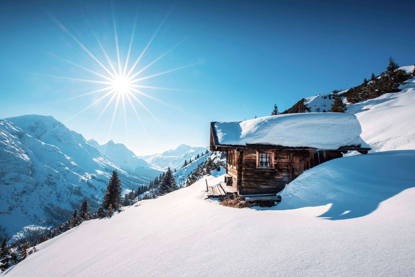 Soleil d'hiver au-dessus de la cabane en bois.