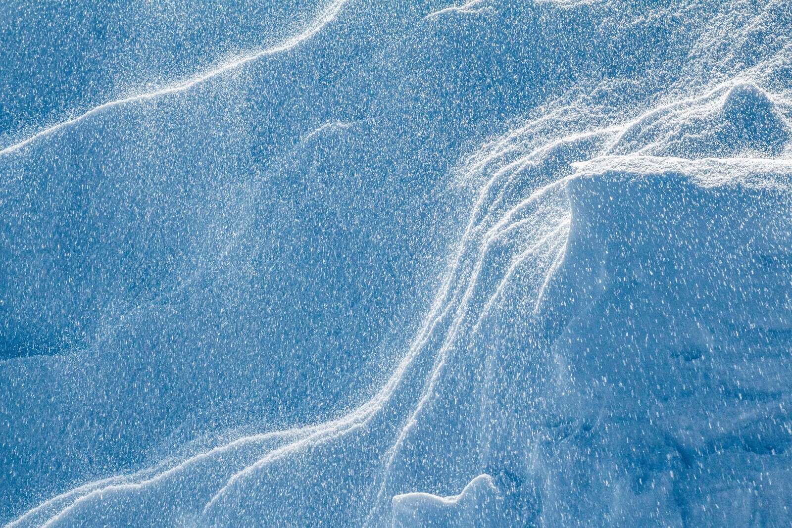 Tourbillonnant de neige sur un paysage bleu glacial
