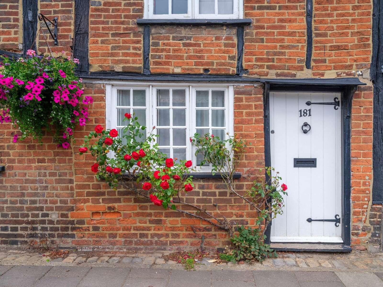 cottage en briques avec des roses rouges