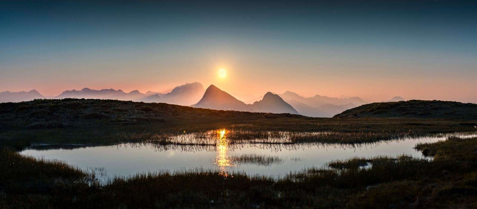 Soleil du soir au-dessus d‚Äôun lac de montagne