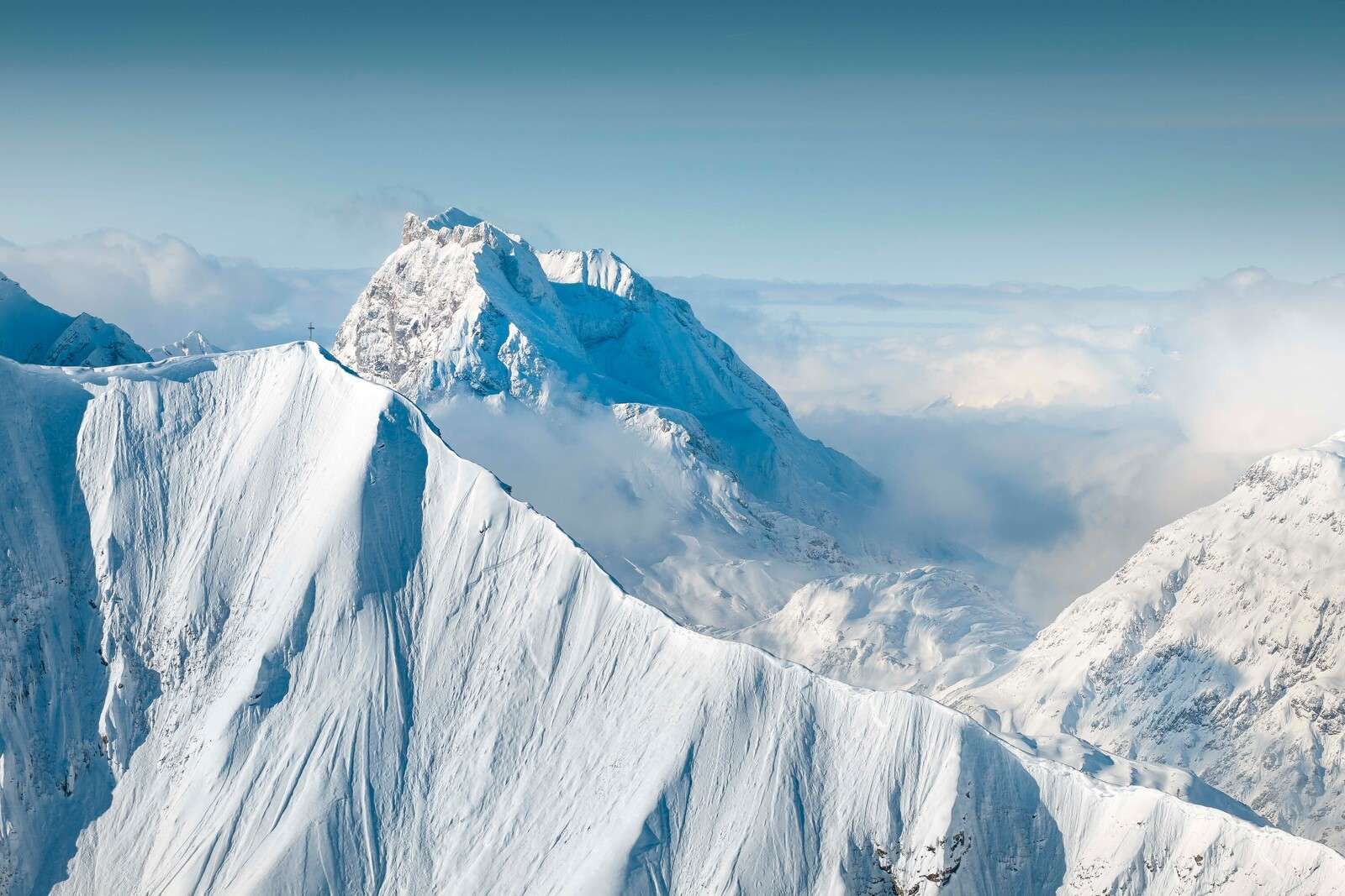 Montagnes enneig√©es au-dessus de la couche nuageuse